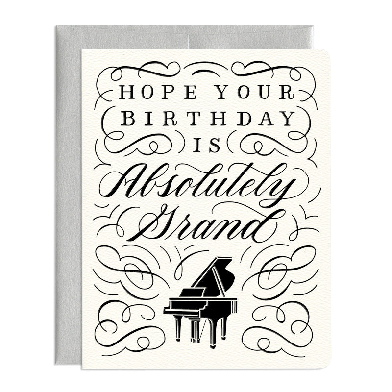 A musical grand piano surrounded by artistic lettering. It says 'Hope Your Birthday is Absolutely Grand'.