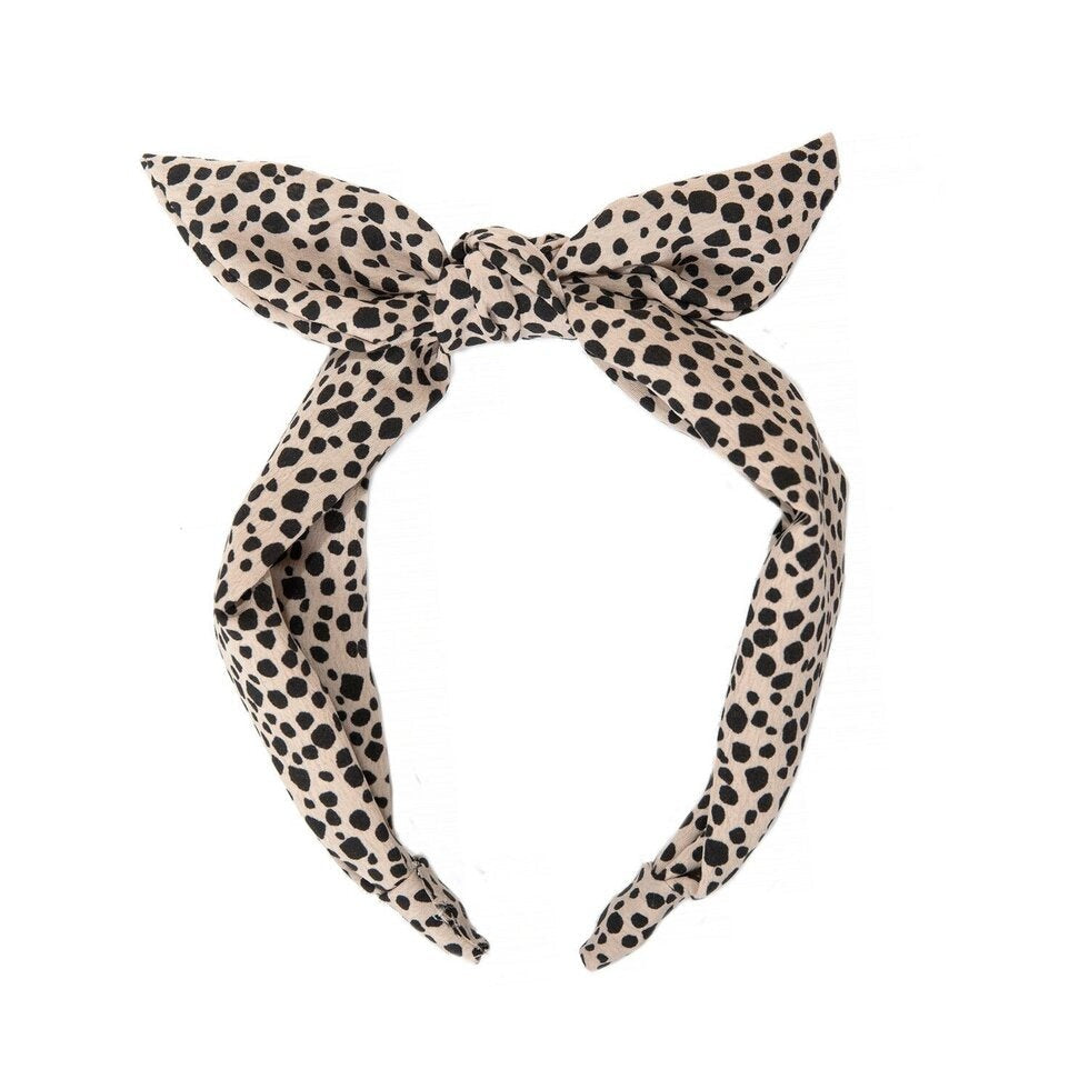 A fabric headband with leopard print, tied in a bow at the top.