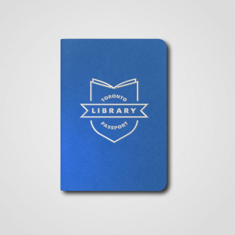 Blue notebook with 'Toronto Library Passport' logo on a gray background