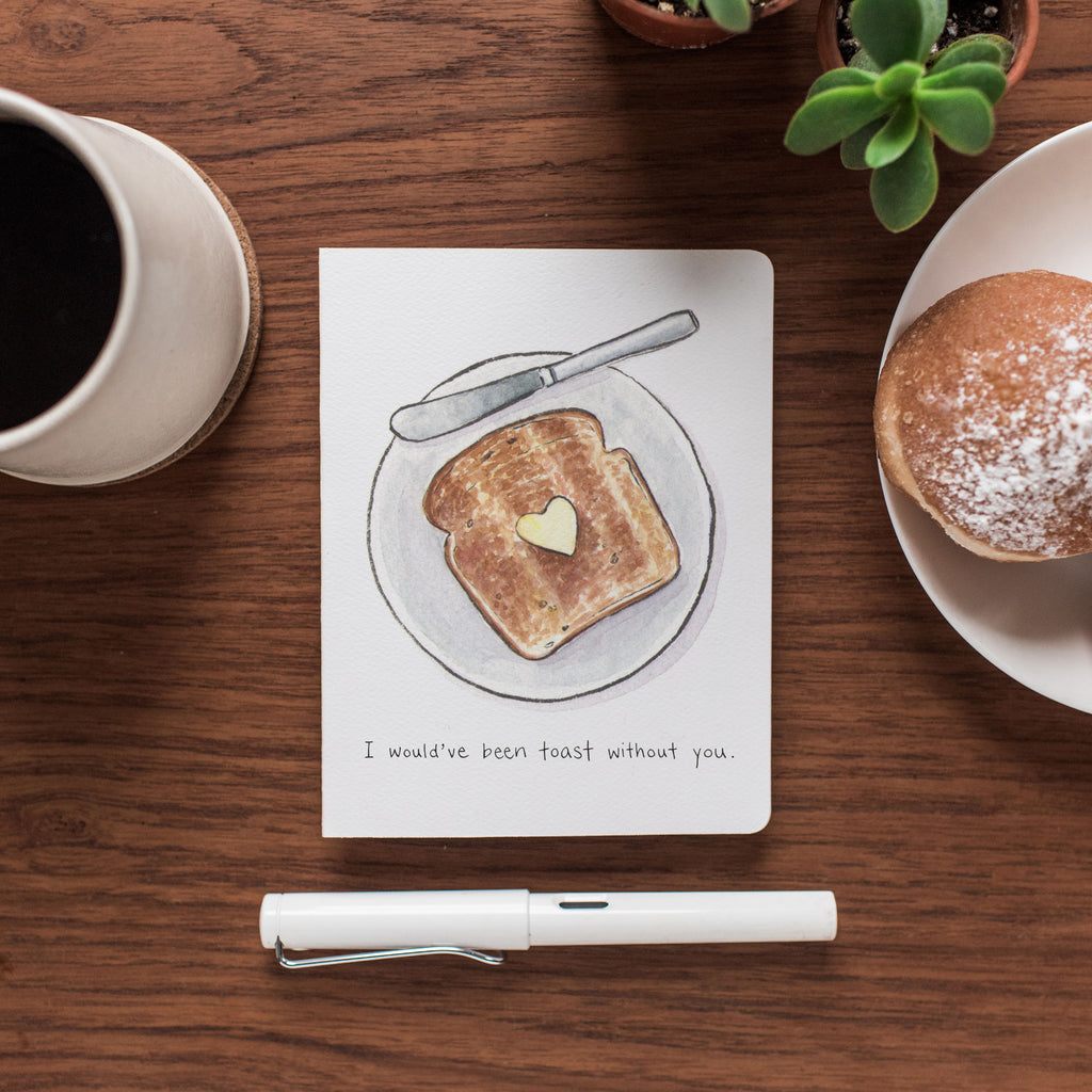 Thankful Toast card rests on a wooden table near a cup of coffee.