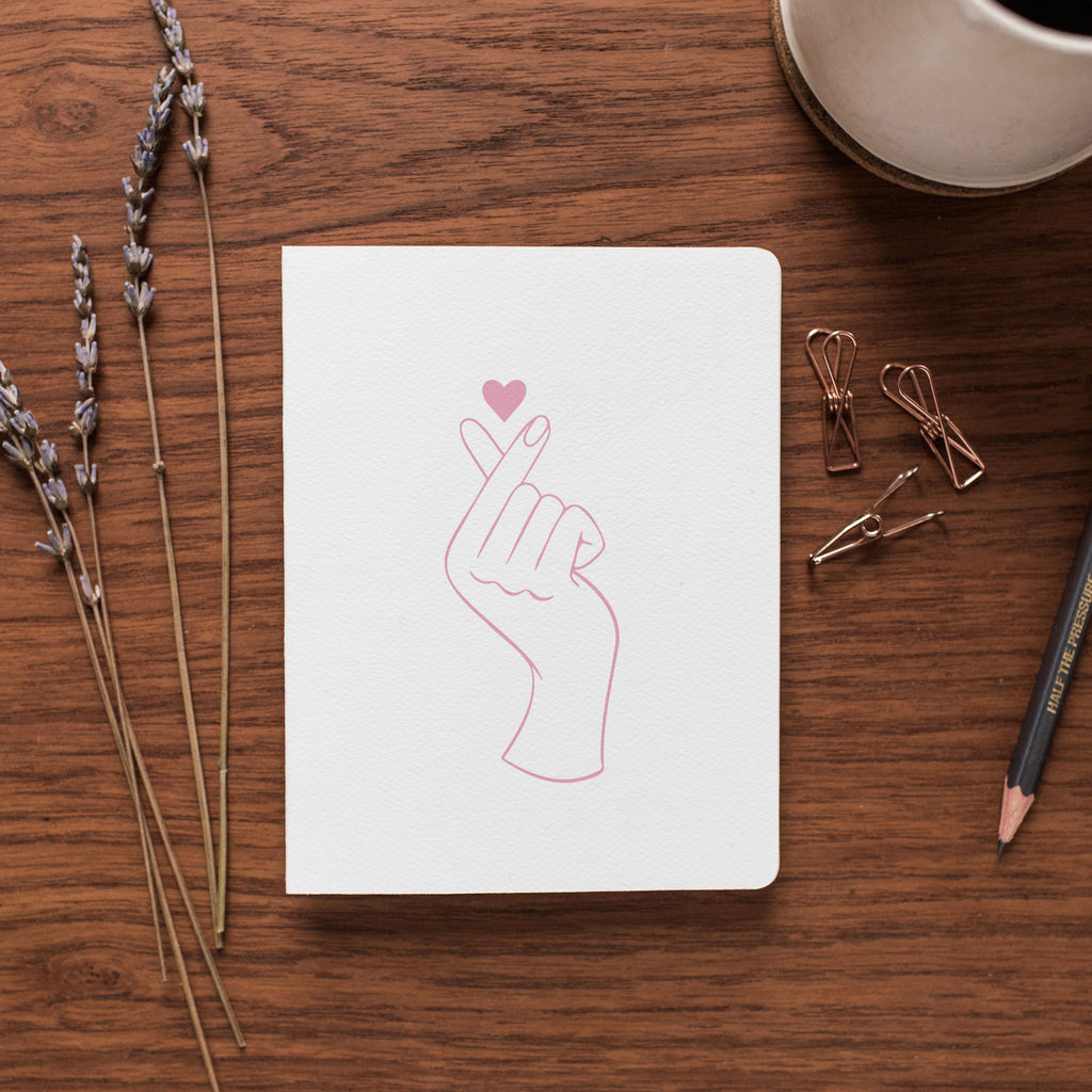 The Fingerheart card rests on a desk surrounded by dried flowers and office supplies.